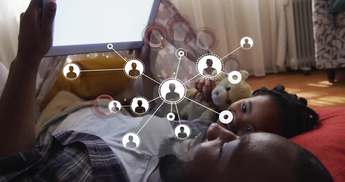 Dad holding tablet causing tech node map showing links on screen while daughter with bear smiling