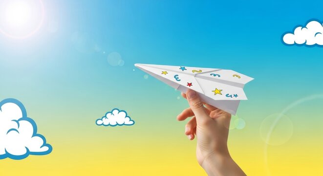 Childs hand holding a decorated paper airplane ready for launch against a vibrant gradient sky with stylized clouds and sun flare.