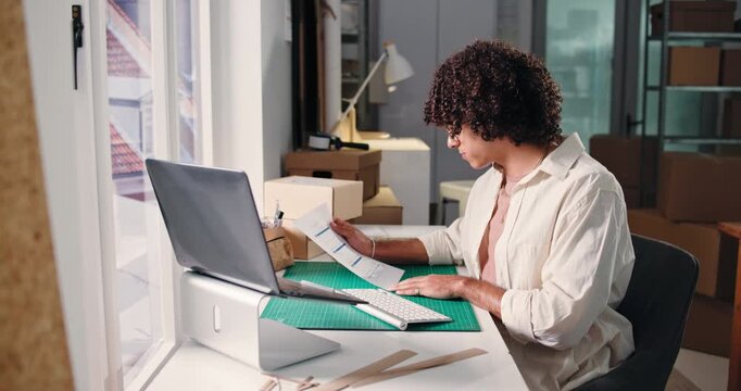 Man, reading and document for ecommerce startup for stock, supply chain and shipping bills. Person, laptop and paperwork with inventory checklist, quality assurance and order invoice on delivery cost