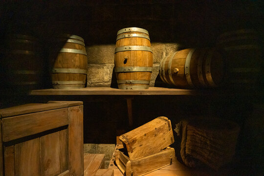 Rustic wooden barrels and crates displayed in a dimly lit cellar in Abu Dhabi, United Arab Emirates