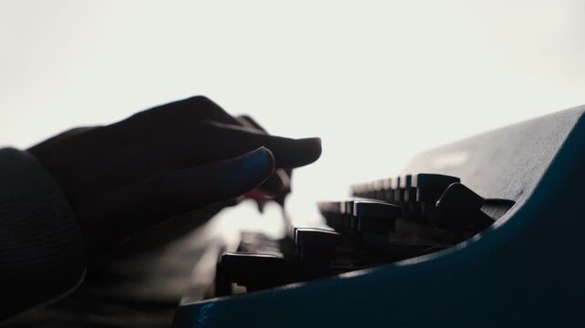 woman's hands typing on an old typewriter with white background