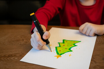 A girl draws a Christmas tree with a marker. High quality photo