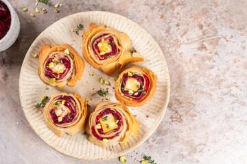 Delicious rose-shaped pastries filled with cheese and cranberry served on a plate
