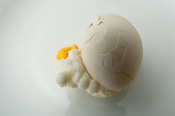 Egg, burst while cooking, with the yolk and egg white oozed out and coagulated.