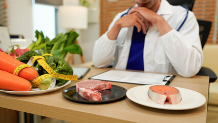 Male dietitian sitting at desk with different healthy products and writing diet plan, Healthy life style concept, doctor writing, diet and losing weight