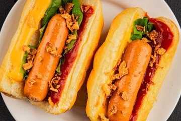 Hotdog fried onions, sausage, bun, sauce fast food tasty snack fresh delicious gourmet food background on the table rustic top view copy space