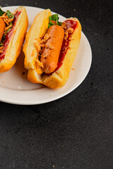 Hotdog fried onions, sausage, bun, sauce fast food tasty snack fresh delicious gourmet food background on the table rustic top view copy space