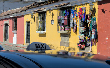 Colorful woven fabric souvenirs outside tourist gift shop on a colorful colonial street in Antigua, Guatemala, a popular tourist travel destination in Latin America.