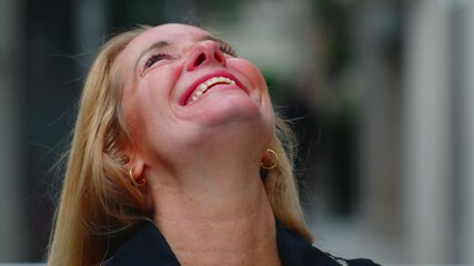 Portrait of middle-aged woman smiling confidently outdoors, relaxed posture and joyful expression conveying warmth and openness