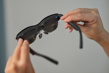 A man holding smart AR glasses in hands
