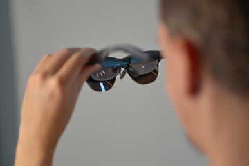 A man holding smart AR glasses in hands