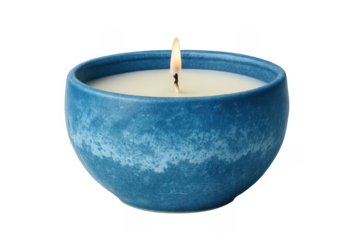 Scented candle burning in blue ceramic bowl