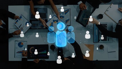 Aerial view of a diverse team engaged in collaboration with digital tools and data analytics, representing modern business dynamics and innovative strategies for success. Raster