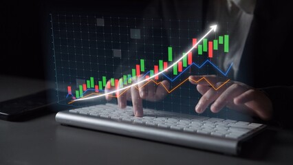 A businessperson analyzes financial data using a keyboard, showcasing a digital graph on screen. The modern workspace emphasizes technology and market trends. Copula