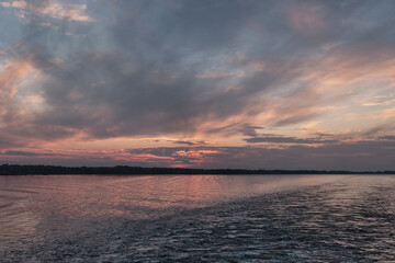Dramatic sunset on Volga river with pink and gray clouds, Russia