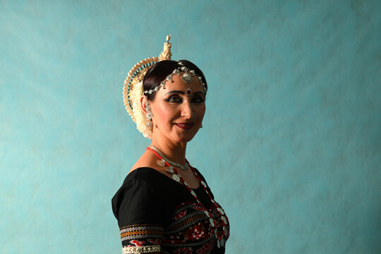 Indian dancer girl in studio on blue background in full-face close-up