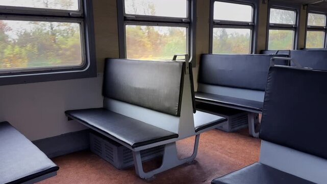 Inside a salon with empty passenger seats of city rail transports. Seats in old cabin of passenger train. Old interior of urban railway. Old leather armchair seat on passenger train. Salon Interior