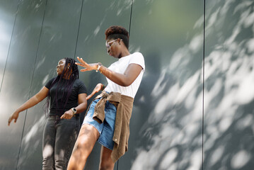 Two young women enjoying an energetic outdoor moment together, expressing positive emotions,...