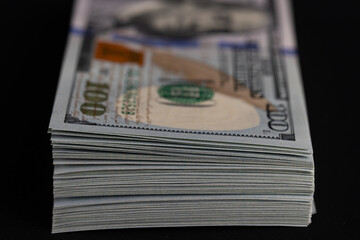 Close Up Stack of New One Hundred US Dollar Bills on Black Background