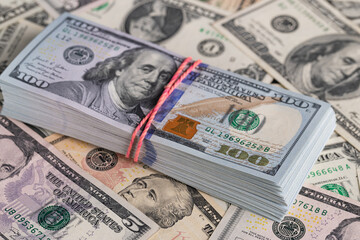 Close Up Stack of New One Hundred US Dollar Bills on Scattered Money Background