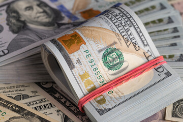 Close Up Stack of New One Hundred US Dollar Bills on Scattered Money Background