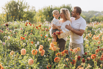 Happy family enjoying summer day picking flowers