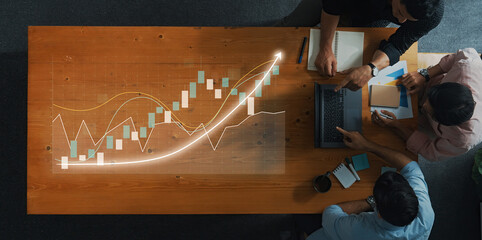 A diverse team engages in a financial analysis meeting, reviewing growth trends and data insights on modern technology in a collaborative workspace environment. Axiom