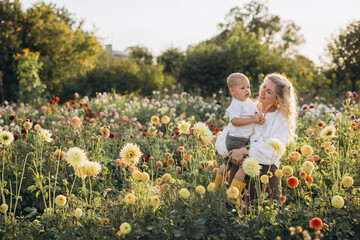 Mother carrying son enjoying day in dahlia garden