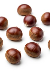 Obraz premium Raw Chestnuts on a White Surface - Closeup of whole chestnuts on a white backdrop. Symbolizing autumn, food, harvest, nature, and nutrition