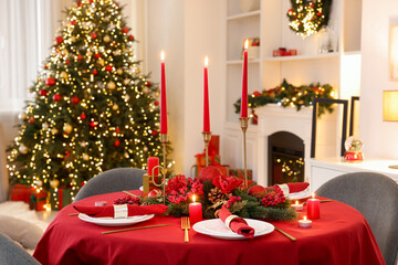 Stylish Christmas table setting with plates, festive decor and burning candles indoors