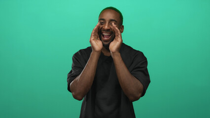 Man cupping hands to mouth calling and smiling with visible braces in studio against a teal green backdrop; joyful energy.