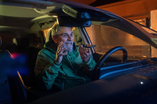 Businessman ignoring safety and sending voice message on mobile while driving