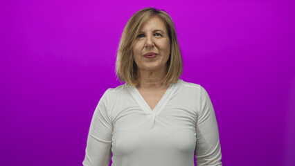 Obraz premium Woman raising palms in a purple studio with expressive open hands gesture and animated facial expression; surprise.