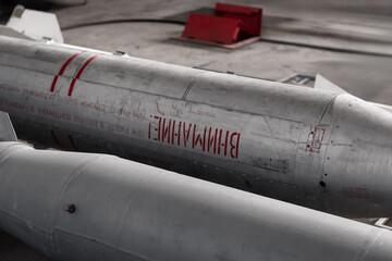 Soviet-era cluster munition dispenser. The cylindrical aluminum fuselage with word "attention" written in cyrillic, likely bulgarian. 