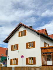 White house with tiled roof and wooden details