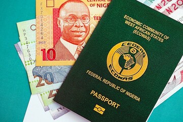 Nigerian naira currency money bills and passport lies on flag close up. The concept of travel and vacation