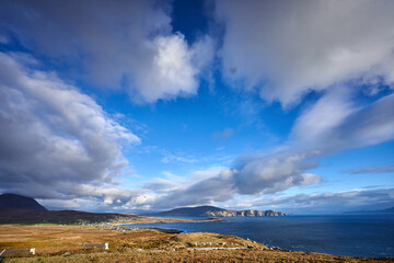 View over the ocean in cloudy blue sky weather with Achill island, Keel vilage and beach