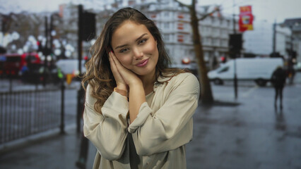 Fototapeta premium Hispanic woman in beige shirt rests head on hands on wet street beneath blurred traffic lights; serenity.