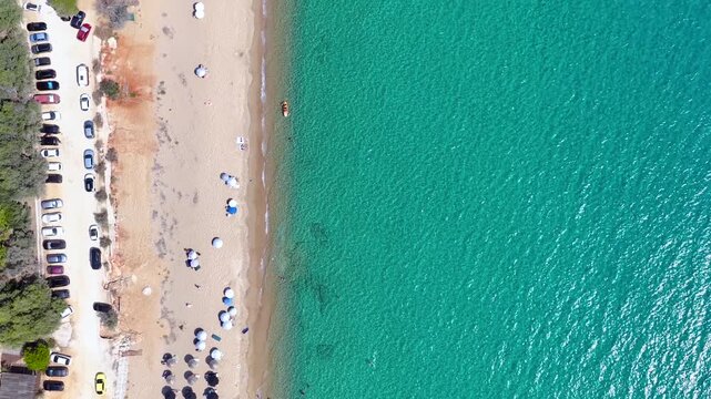 Aerial overhead view of the beautiful Chrysi Akti beach at Navarino Coast, Messinia, Greece, with emerald sea and sand dunes