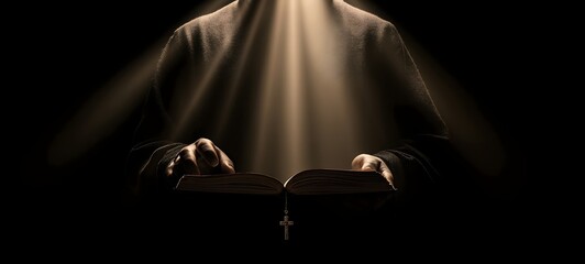 Monk reading holy book with light rays and cross pendant