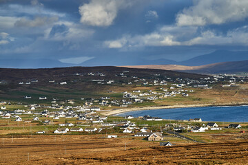 View over the ocean in cloudy blue sky weather with Achill island, Keel vilage and beach