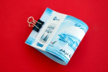 United Arab Emirates dirham money bills in big amount on red close up. Finance and banking concept