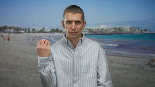 Man contemplating at a sunny beach with calm sea in the background and wearing casual shirt. - Powered by Adobe