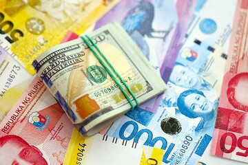 Philippines peso currency money bills and bunch of us dollar banknotes close up. The concept of...