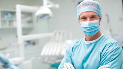 Surgeon in blue scrubs poses confidently with arms crossed in a modern hospital operating room
