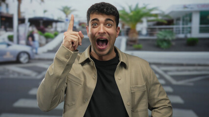 Man pointing finger upward at city crosswalk; idea inspiration.