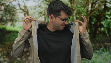 Man lifts hands in a shrug outdoors while hispanic young guy adult person stands outside.