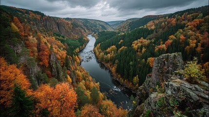 Majestic autumn canyon river vista showcases vibrant fall foliage and dramatic rocky cliffs under a moody sky
