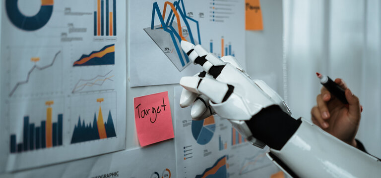 A robotic hand is seen analyzing detailed business charts and graphs pinned to a wall, showcasing data visualization and technology integration in the modern office.Noogenesis