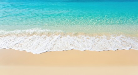 A closeup view of gentle ocean waves washing onto a pristine sandy beach, showcasing the clear turquoise water and the soft texture of the shoreline